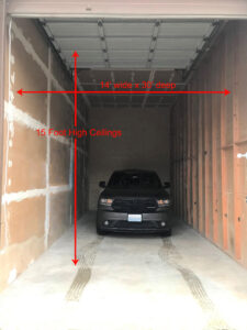 Black SUV parked inside a spacious storage unit with dimensions labeled: 14' wide, 39' deep, 15' high ceilings.